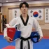 Practicante de artes marciales con dobok y peto oficial de equipamiento de taekwondo