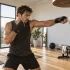 Boxeador entrenando con pera de velocidad en un gimnasio luminoso para mejorar reflejos y coordinación